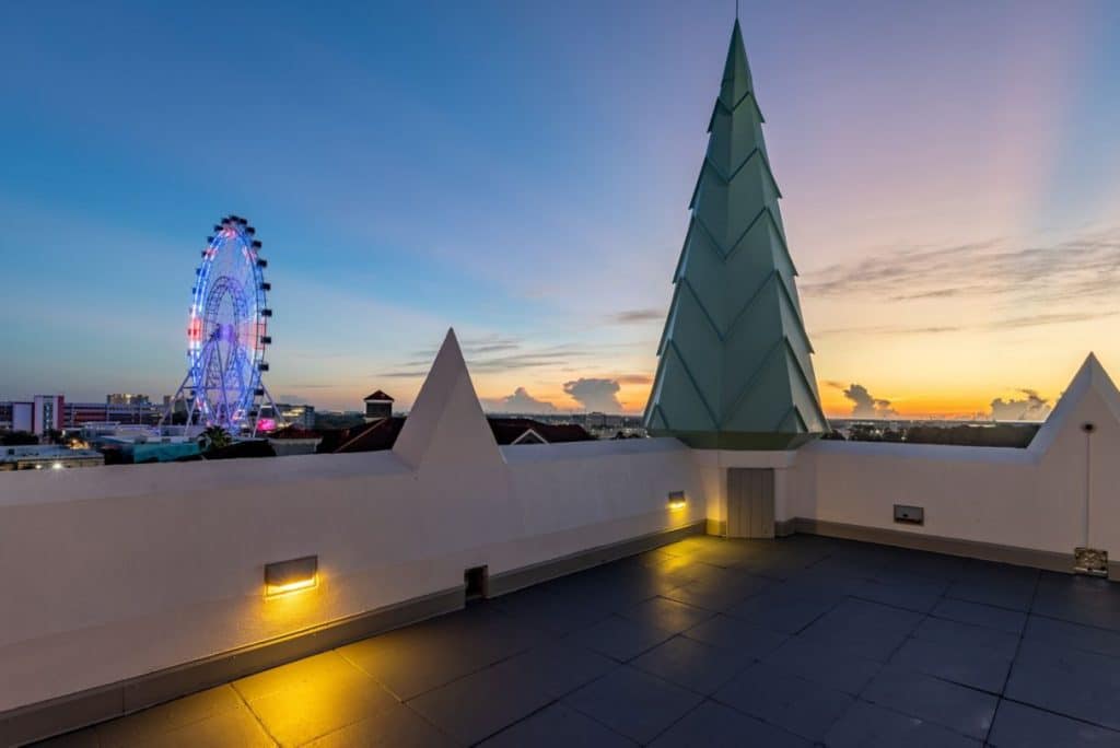 Rooftop area at the Castle Hotel, ferris wheel in the background, large green tree design on the roof, Central FL