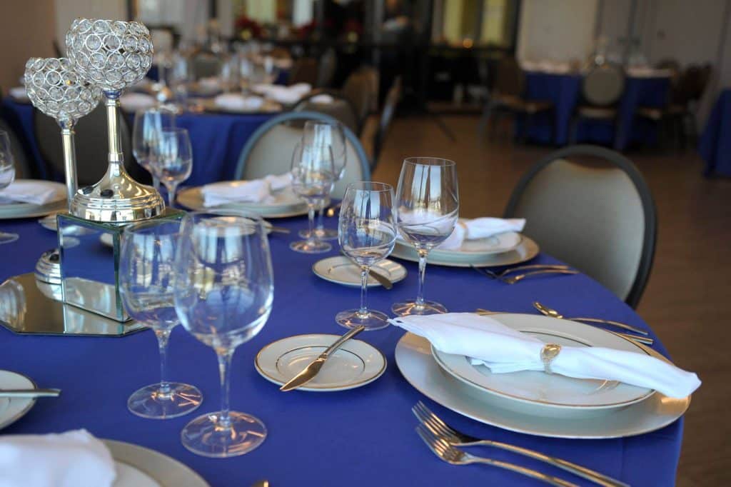 tablescape, blue tablecloth, silver chargers, white napkins, clear glassware, silver and black chairs, Orlando, FL