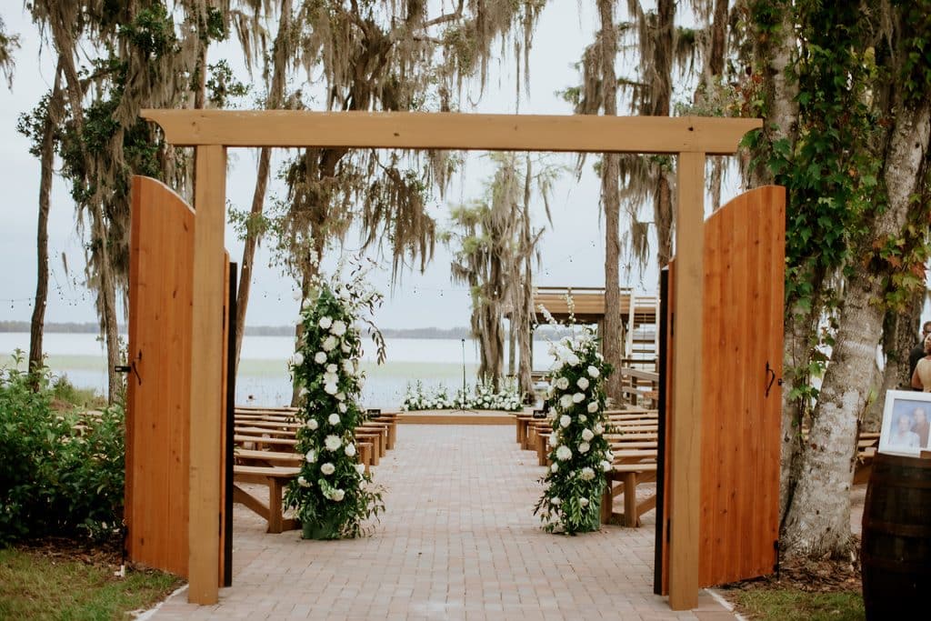 Wooden arch with doors for the bride to walk through to walk down the aisle