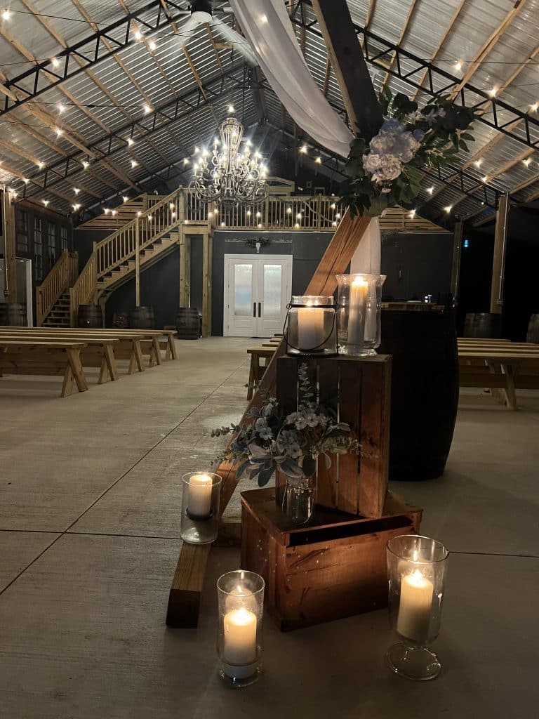 wedding venue, indoors, wooden benches, twinkle lights, white candles, wooden boxes, Orlando, FL