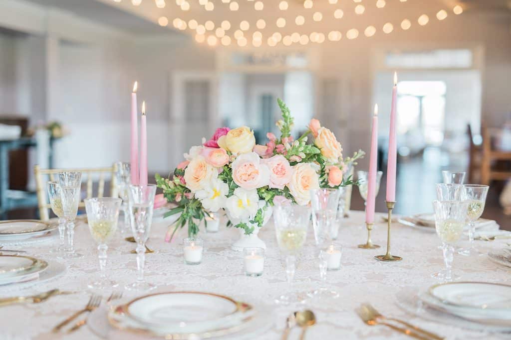 beautiful floral arrangement as a centerpiece with peach and pink flowers, long pink candles around the table, white votive candles, gold flatware, white chargers with gold trim, Tuscawilla Country Club, Orlando, FL