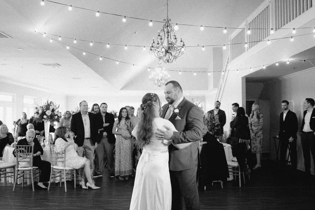 black and white photo, bride and groom dancing on the dance floor at their reception, twinkle lights above, Orlando, FL