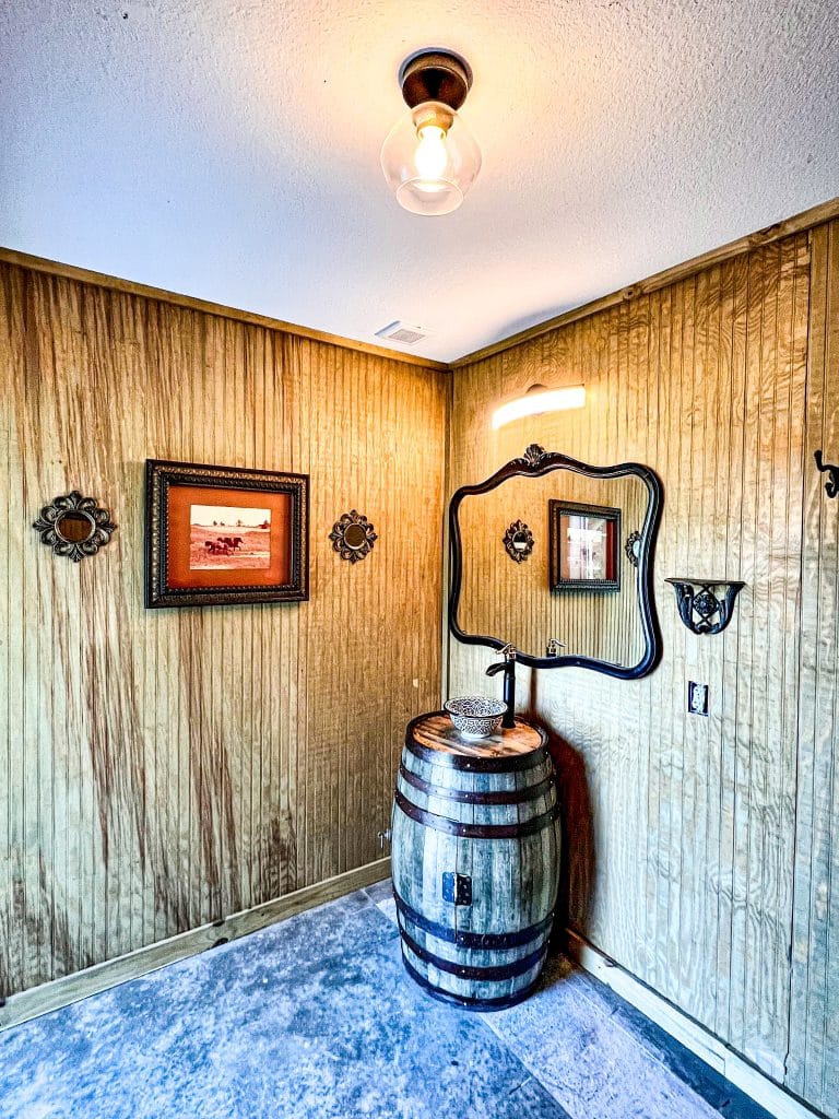 dressing room area, mirror on the wood paneled wall, wood barrel doubling as a sink, blue carpet, Orlando, FL