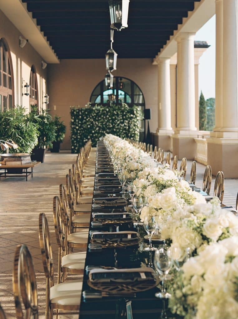 wedding reception, long table, white flower centerpieces, black tablecloths, large outdoor columns, Orlando
