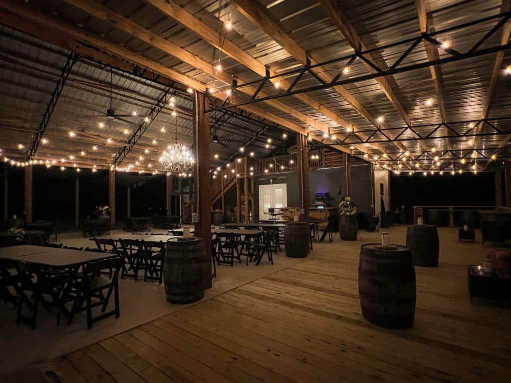 venue at night, twinkle lights, wood tables and chairs, wooden barrels, Grass Campers Event Venue, Orlando, FL