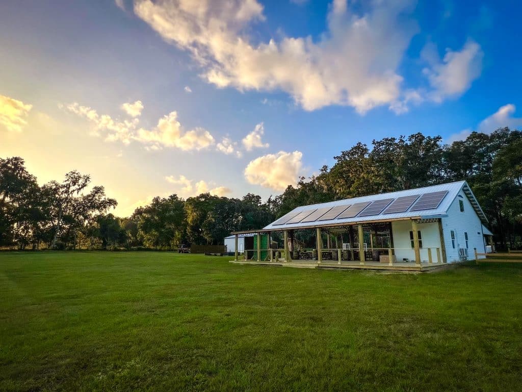 blue skies, white farmhouse type structure, open field, Grass Campers Event Venue, Orlando, FL