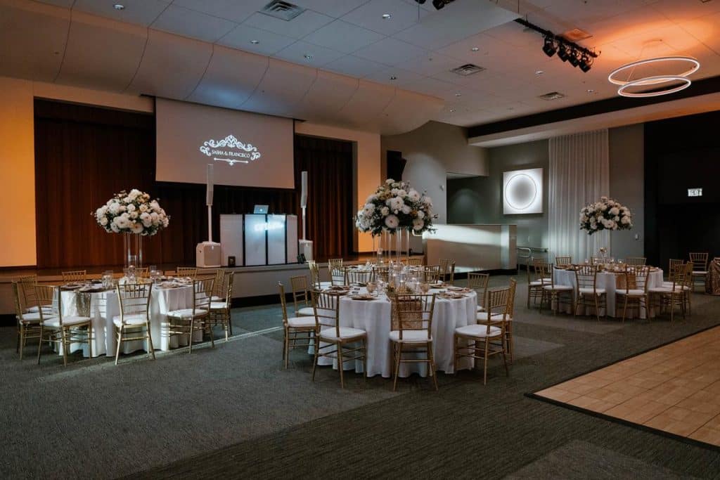 ballroom set up, four table with tall centerpieces of flowers, screen display, uplighting, Orlando, FL