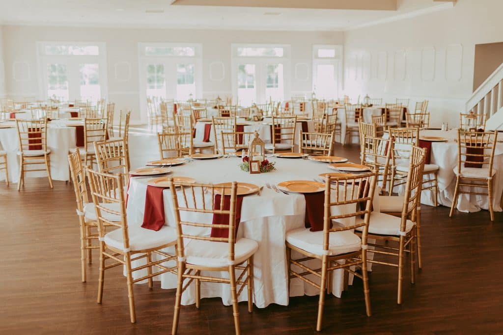 round tables, white tablecloths, red napkins, gold backed chairs, large windows throughout the room, Tuscawilla Country Club, Orlando, FL