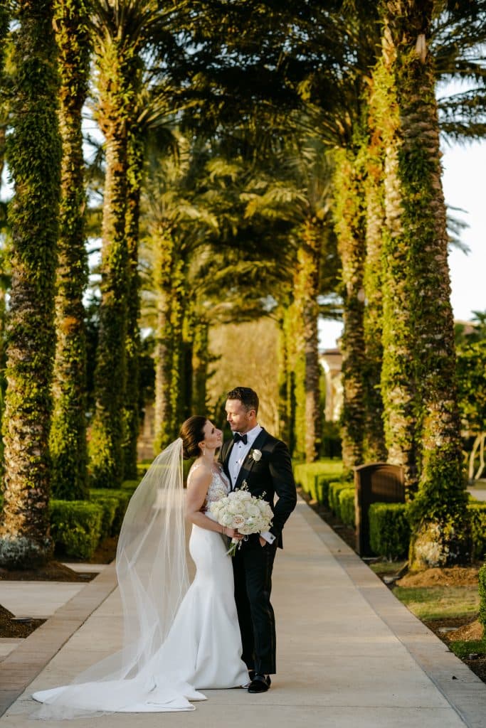 bride and groom embracing, palm trees, sidewalk, Central Florida, Four Seasons Orlando at Walt Disney World Resort