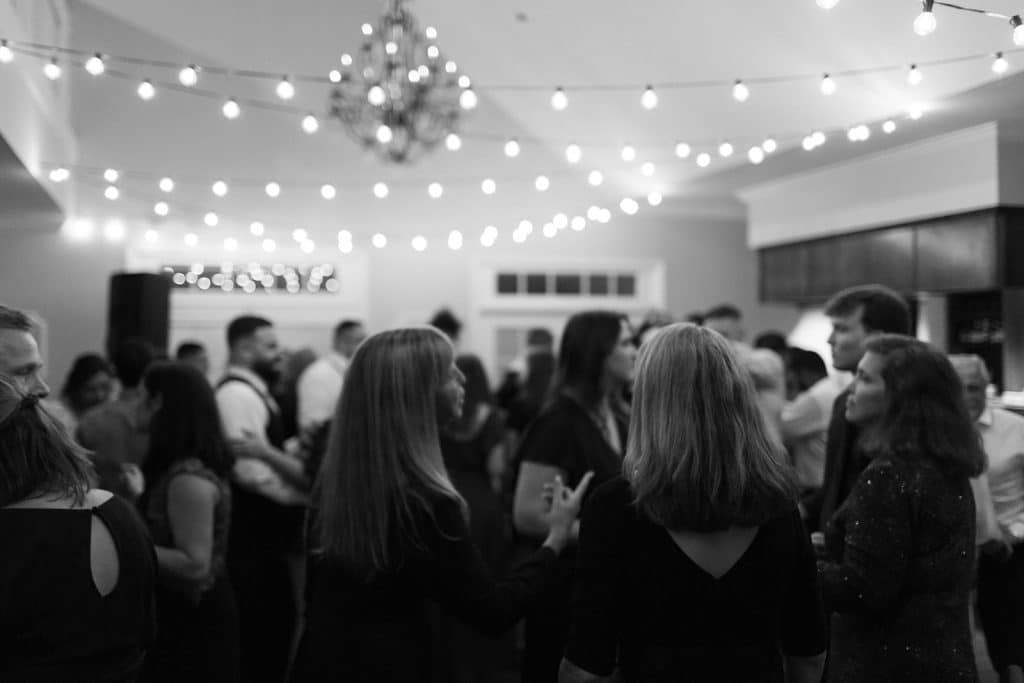 black and white photo, reception with guests dancing, string lights hanging from the ceiling, Tuscawilla Country Club, Orlando, FL