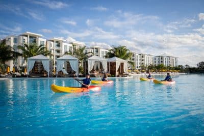 guests kayaking in the water at Evermore Orlando Resort, resort rooms and cabanas in the distance, Orlando, FL