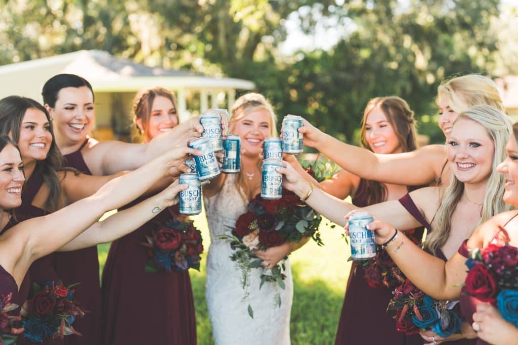 Bridal party with the bride, giving cheers to her, maroon dresses, outdoors, Central FL