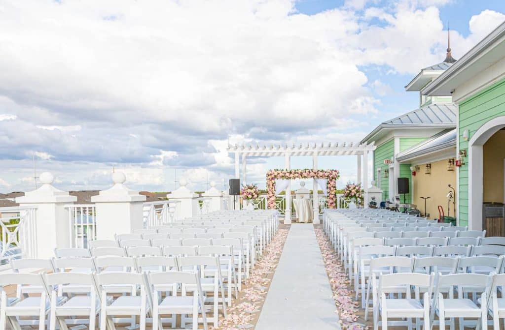 Ceremony set up, altar at the front, white chairs set in two sections with a center aisle, rooftop, Orlando, FL