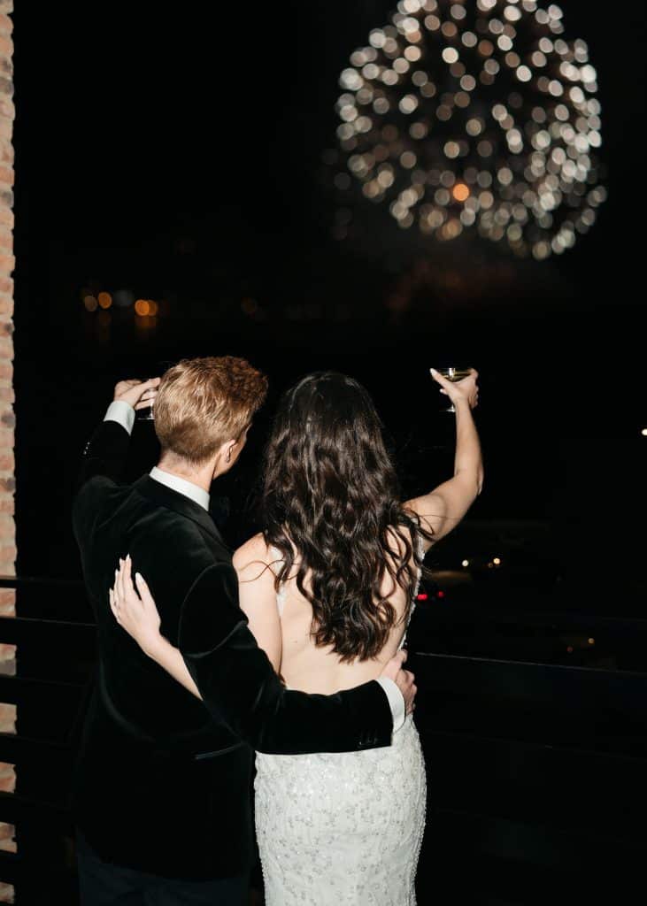 husband and wife celebrating their marriage under the fireworks with a glass of champagne, Orlando, FL