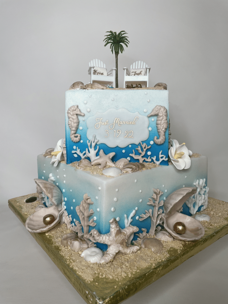 Two layer cake with a beach theme, sea shells, palm trees, adirondack chairs, blue and white shades of fondant, square shaped cake, orlando, fl