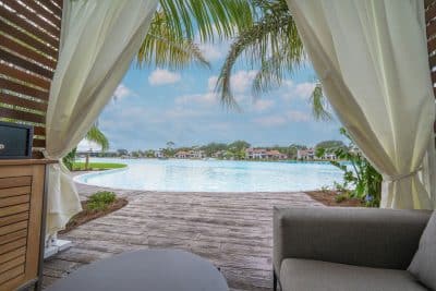 cabana with a light green curtain, facing the water, stone walkway, Evermore Orlando Resort