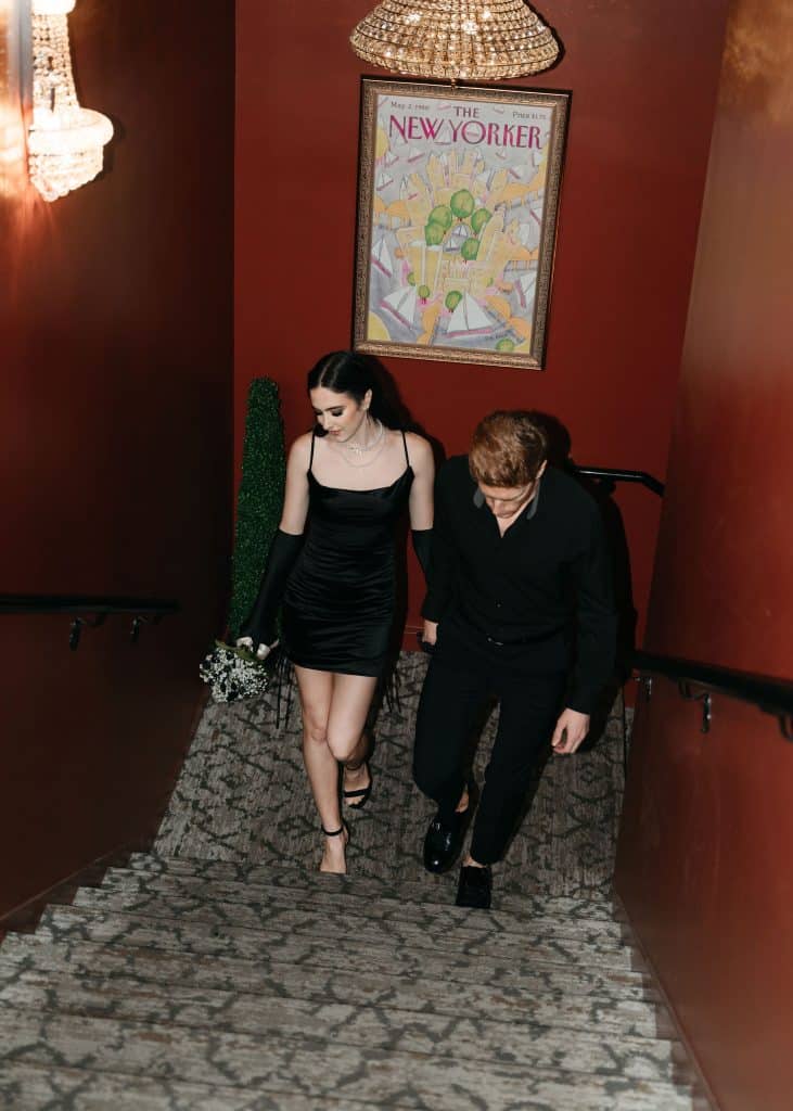 couple walking hand in hand up the stairs, both wearing all black, Orlando, FL