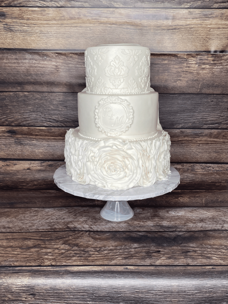 three tiered all white cake, white cake stand, detailed lace decorated on the three layers, wood backdrop, Sugar Divas Cakery, Orlando, FL