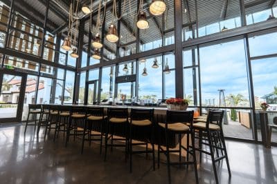resort restaurant facing the water, long wooden table indoors, Evermore Orlando Resort