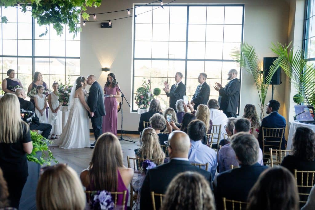 Wedding ceremony, couple kissing, wedding party and guests looking upon the happy couple, Orlando, FL