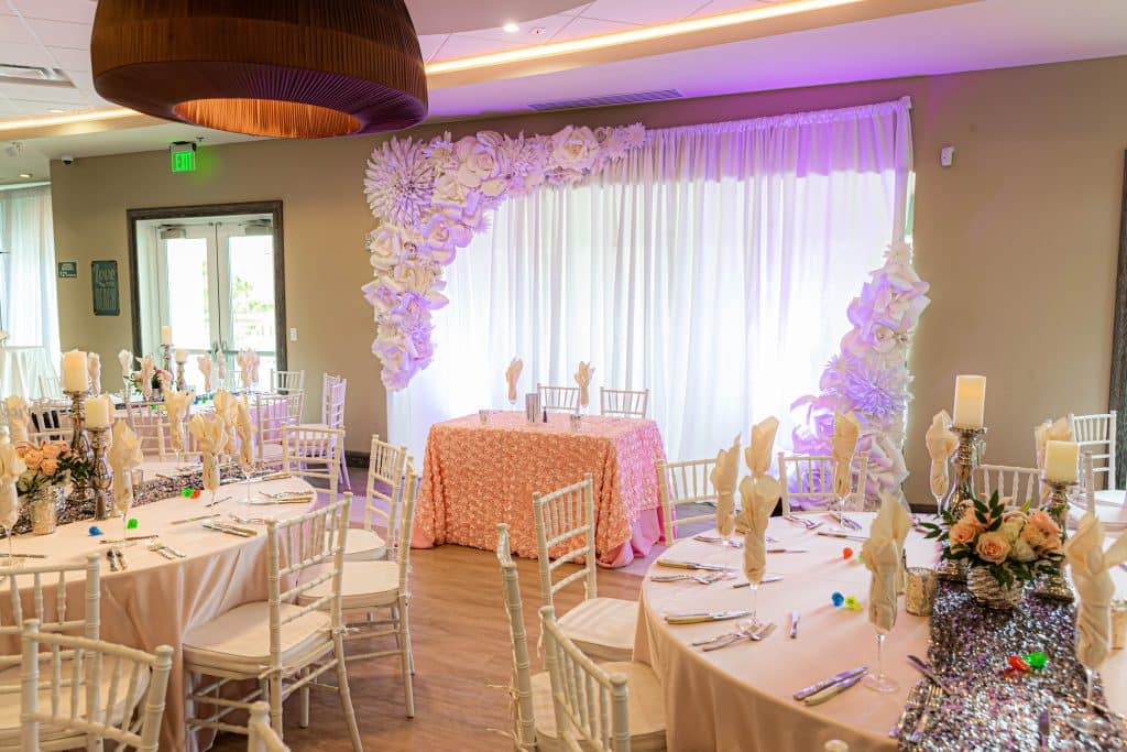 head table with a peach tablecloth, purple uplighting, set up for a party/shower, pink tablecloths, flower centerpieces, Rentyl Resorts, Orlando, FL