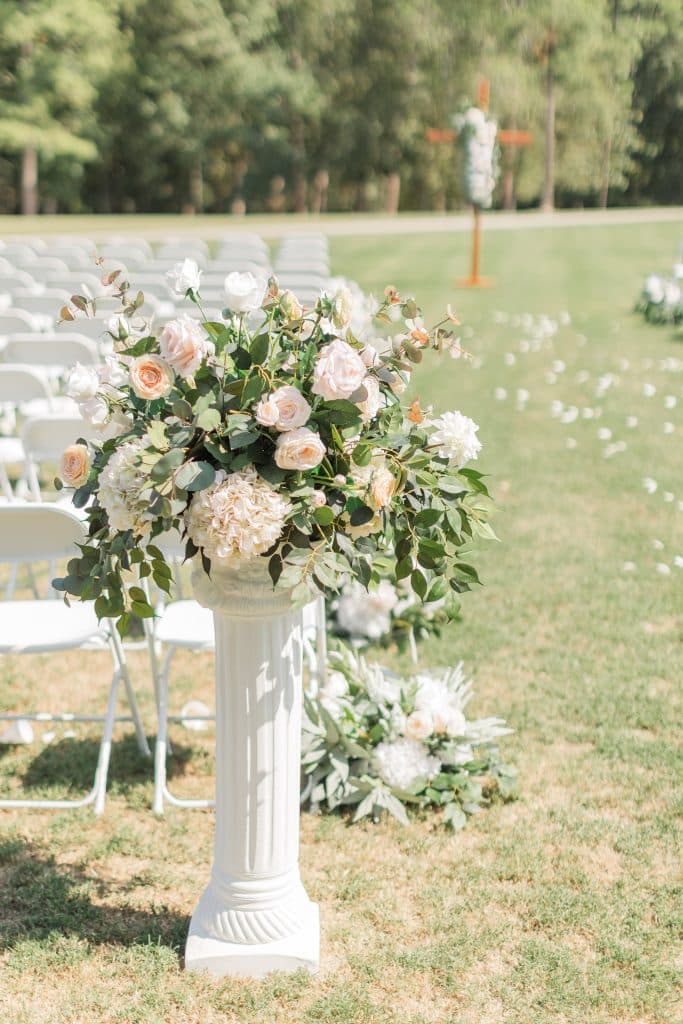 floral arrangement with pink and white flowers, on a white column behind the rows of chairs for the reception, Orlando, FL