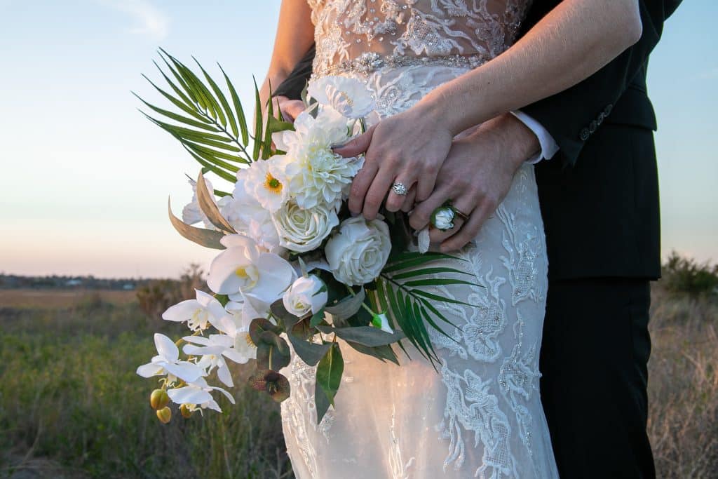 bride's bouquet of white flowers, greenery, bride and groom embracing from behind, FauxReal Flowers, Orlando, FL