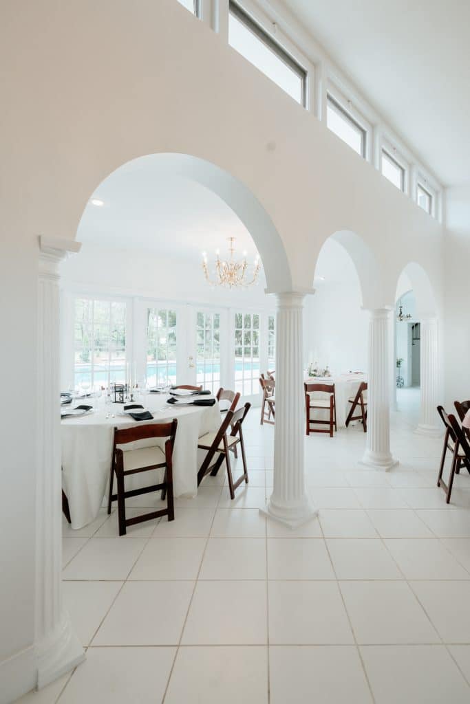 reception room view, 3 arches in the room, tile floor, all white walls, wooden chairs, The Mulberry Estate, Orlando, FL