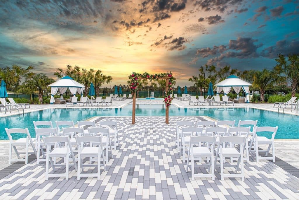 Pool area, pergola with greenery, sunset, white chairs, tile pool deck, Rentyl Resorts, Orlando, FL