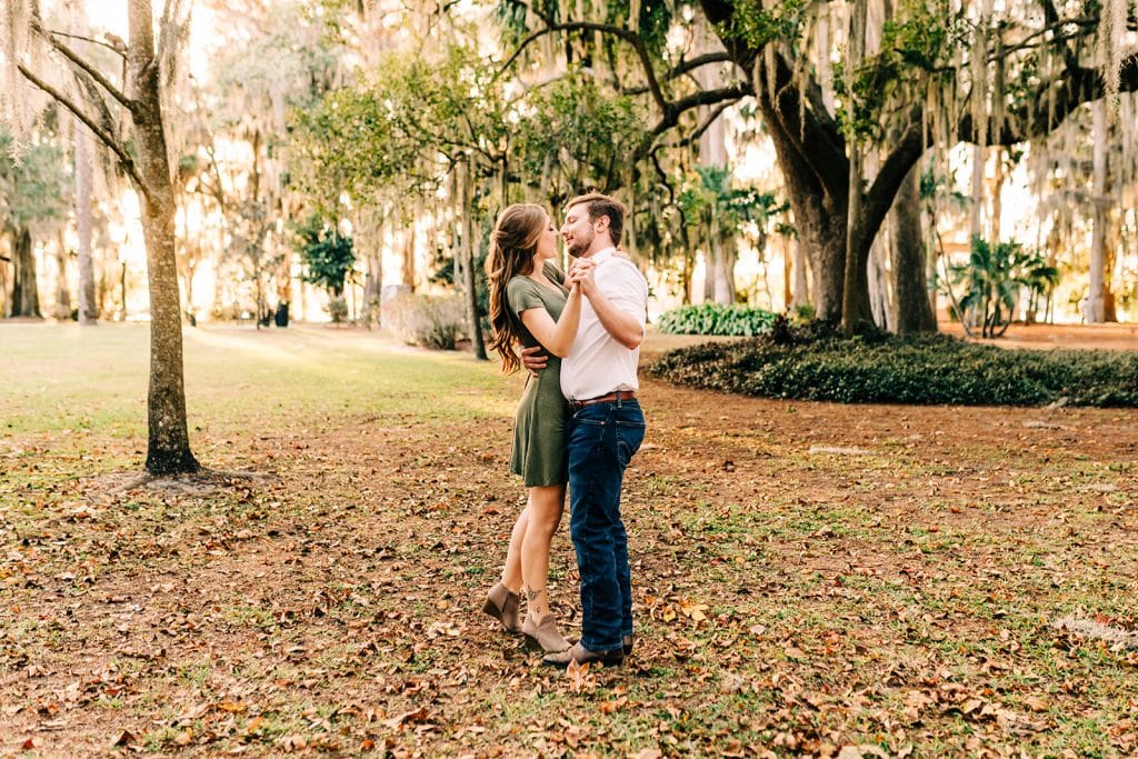 man and woman engagement pictures outside at park