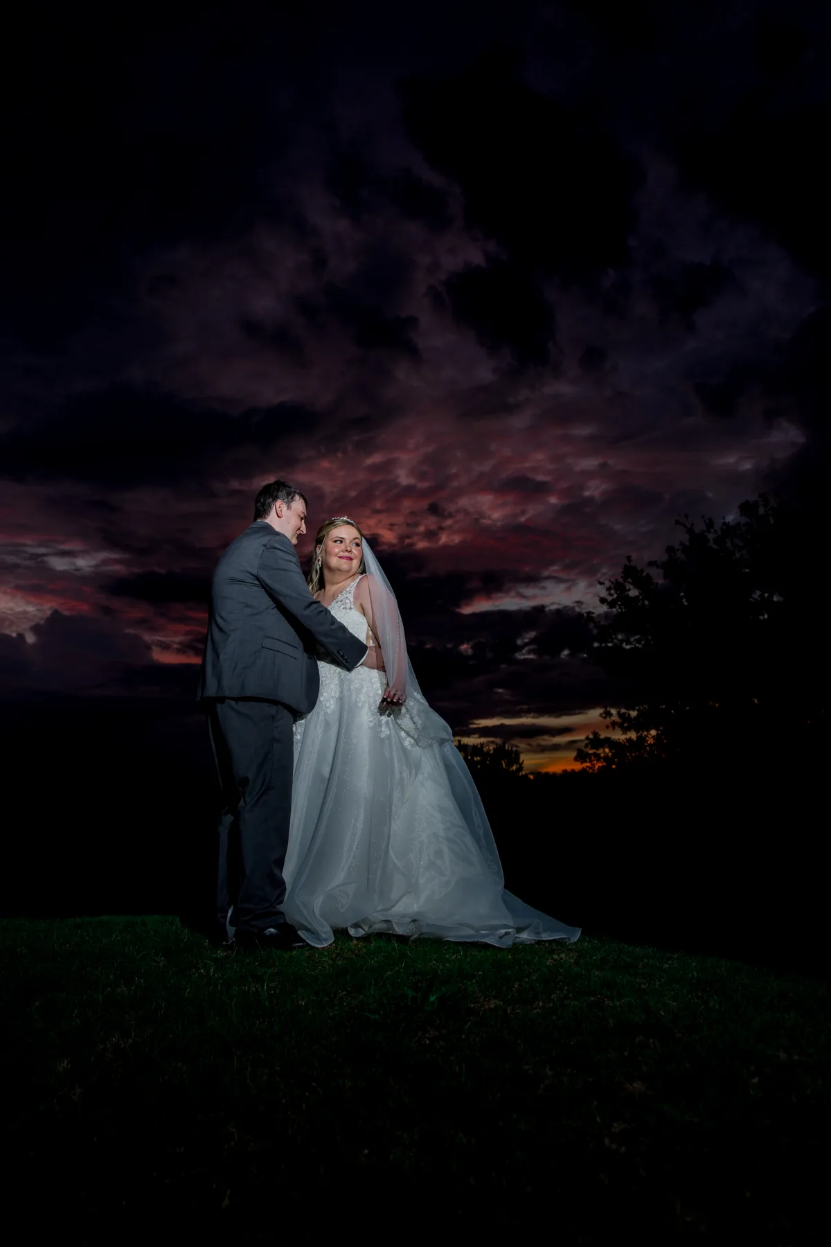 Bride and groom portrait at sunset during their wedding at Falcon's Fire Golf Club in Kissimmee Florida with dramatic purple and red sky backdrop