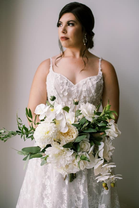 bride with her large floral bouquet of white flowers and green leaves, strapless white gown, Orlando, FL