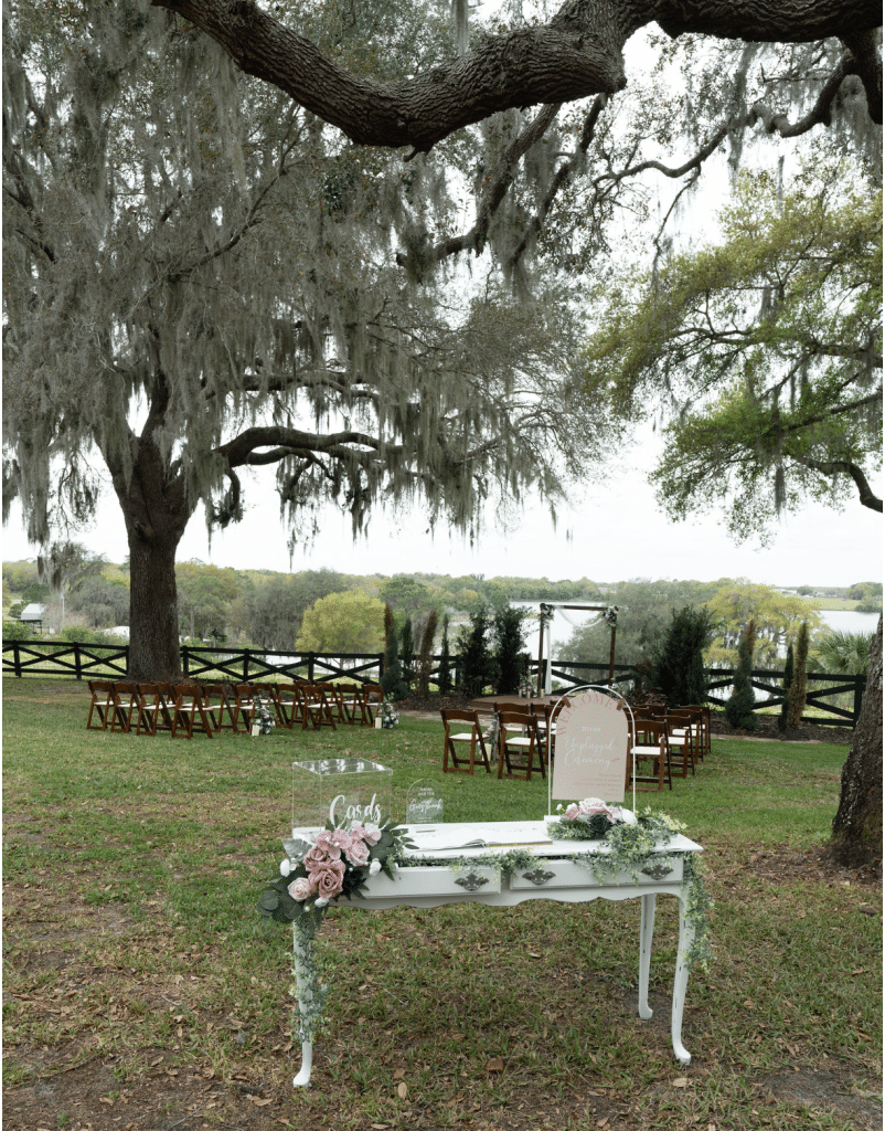 welcome table for guests to sign the guest book, ceremony set up under the willow trees, Orlando, FL