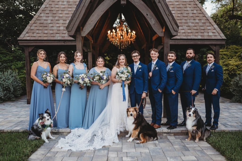 happy couple on their wedding day, posing with their wedding party and their dogs, The Enchanting Barn, Orlando, FL