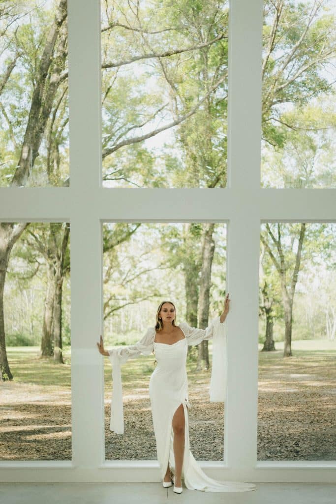 bride posing in front of the large floor length window, in her wedding gown, Orlando, FL