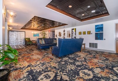 lounge area, large blue sofas, large white doors, ornate decorations on the walls, wall to wall carpet of blue and orange, Eola View, Orlando, FL