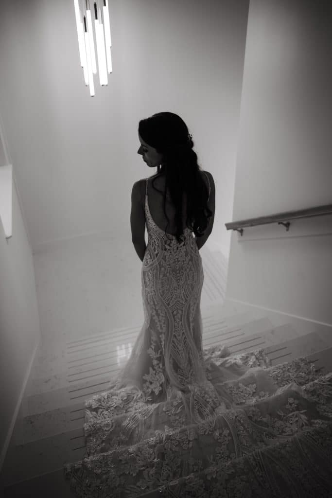 bride standing on the stairs, photo taken from above, her train laid out on the stairs, black and white photo, Orlando, FL