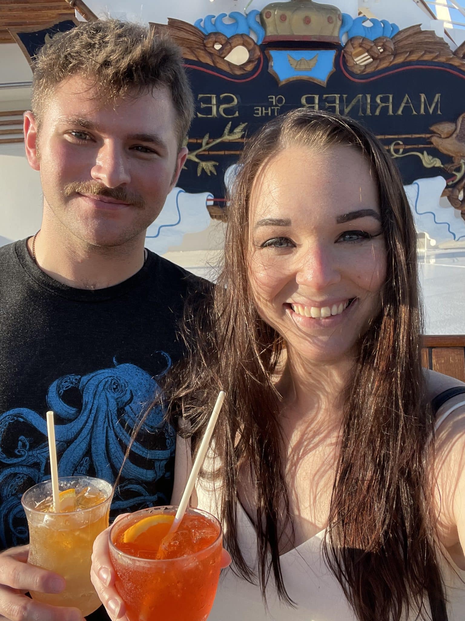 couple posing for picture while holding drinks