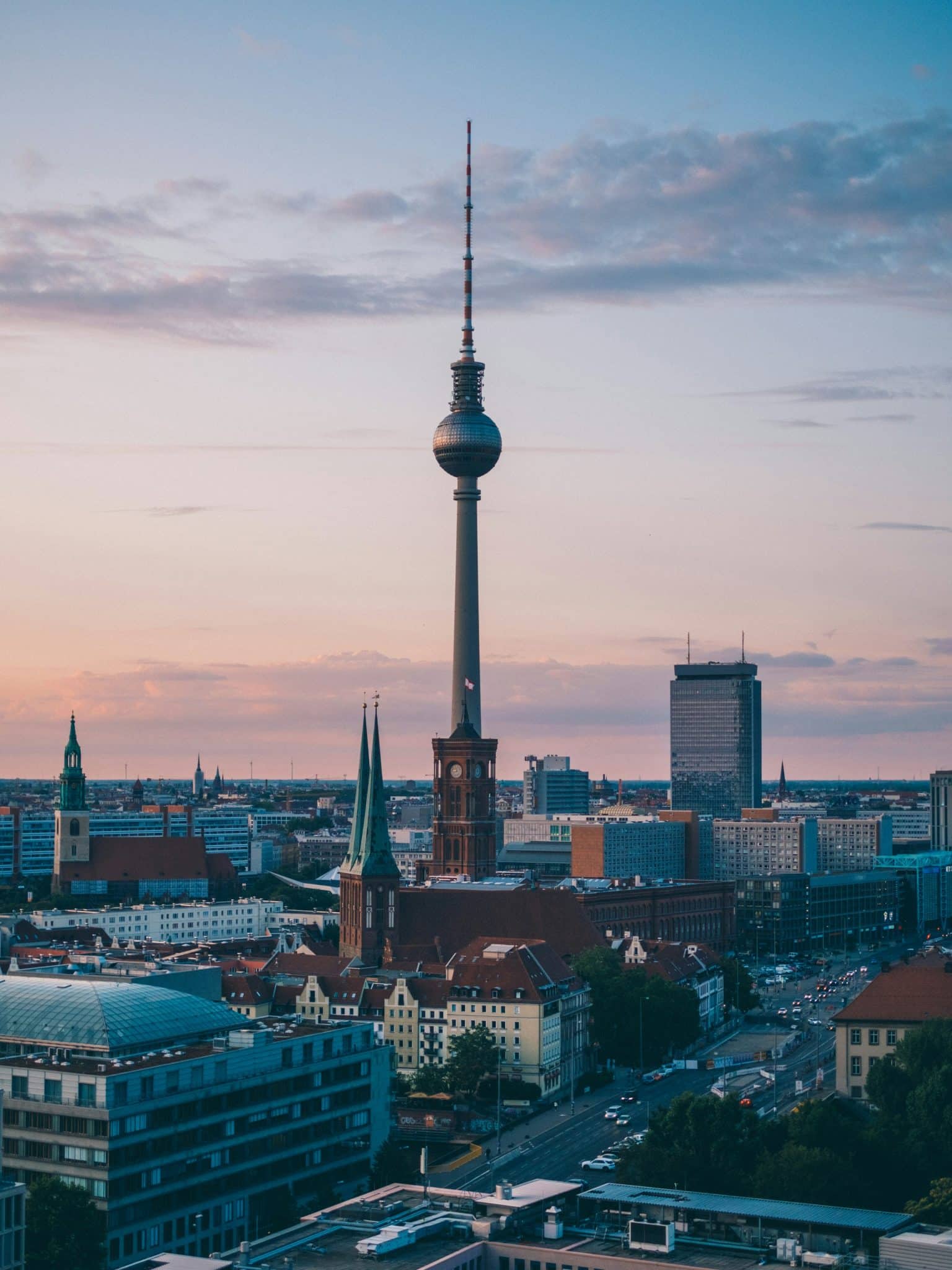 city shot of tall tower like building during dusk with a purple and deep blue sky