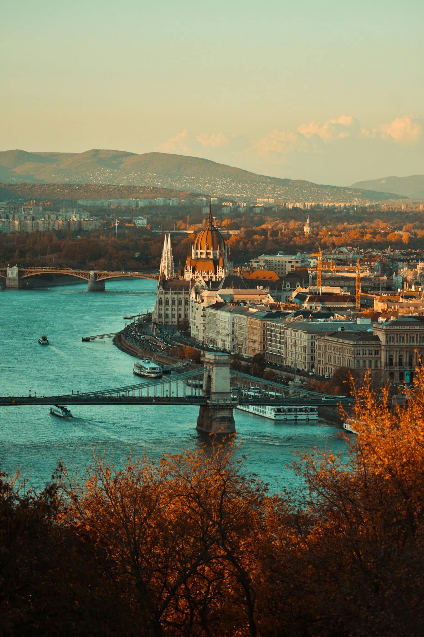 colorful fall image of waterfront town during sunset with mountains in the distance