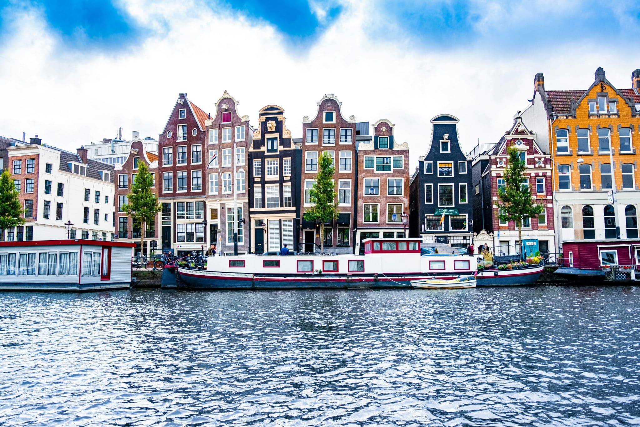 townhomes along the waterfront with long boats docked in front of them