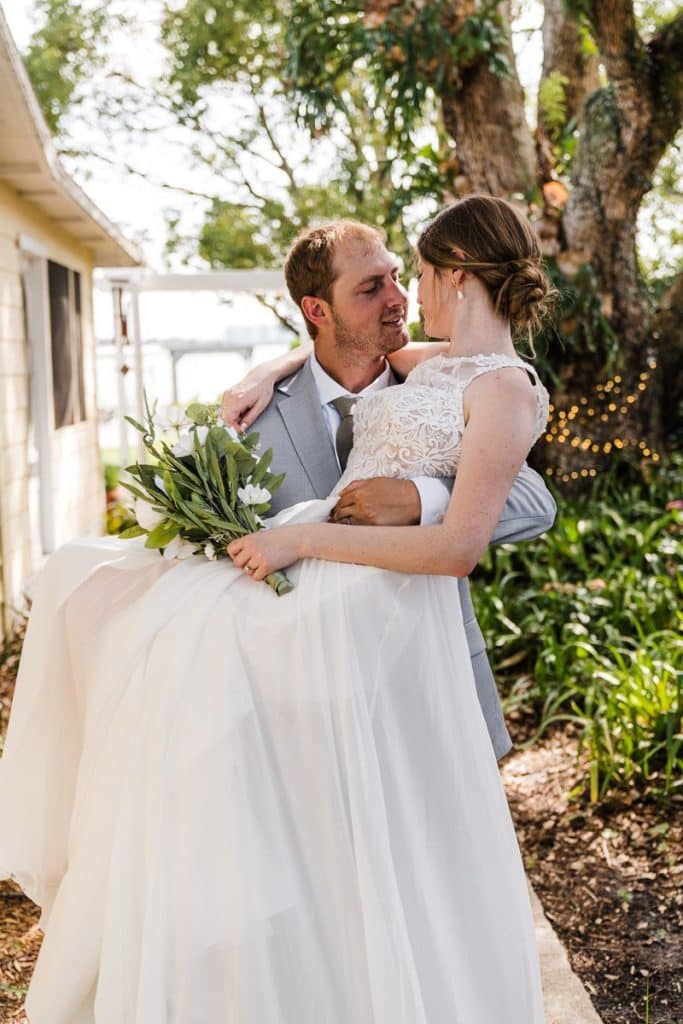 groom holding his bride in his arms, outside, Author Made Photo and Video, Orlando, FL
