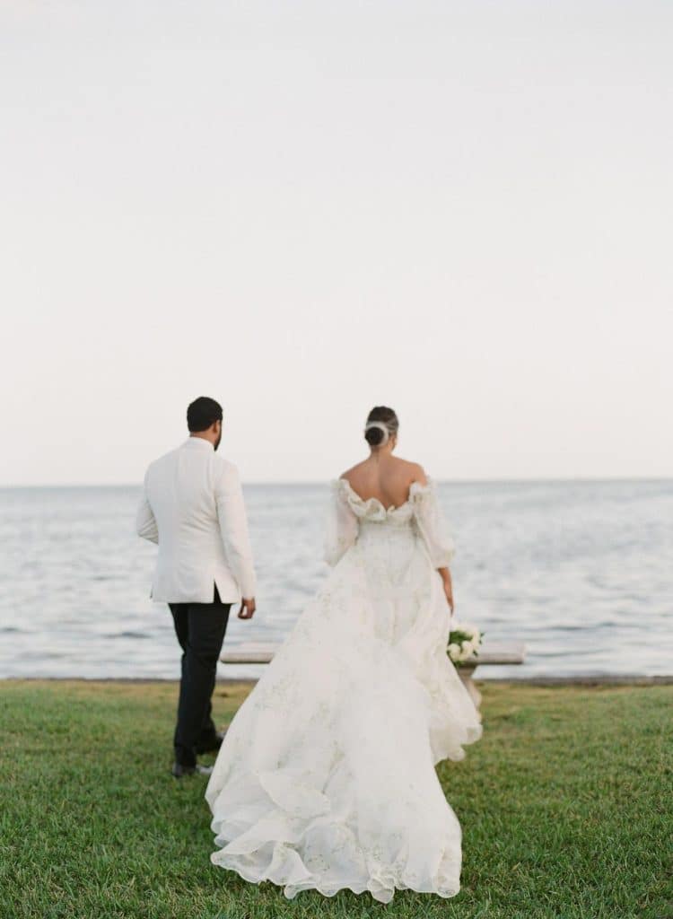 water's edge, bride and groom walking towards the shore, in wedding attire, Naomi Zora Events, Orlando, FL
