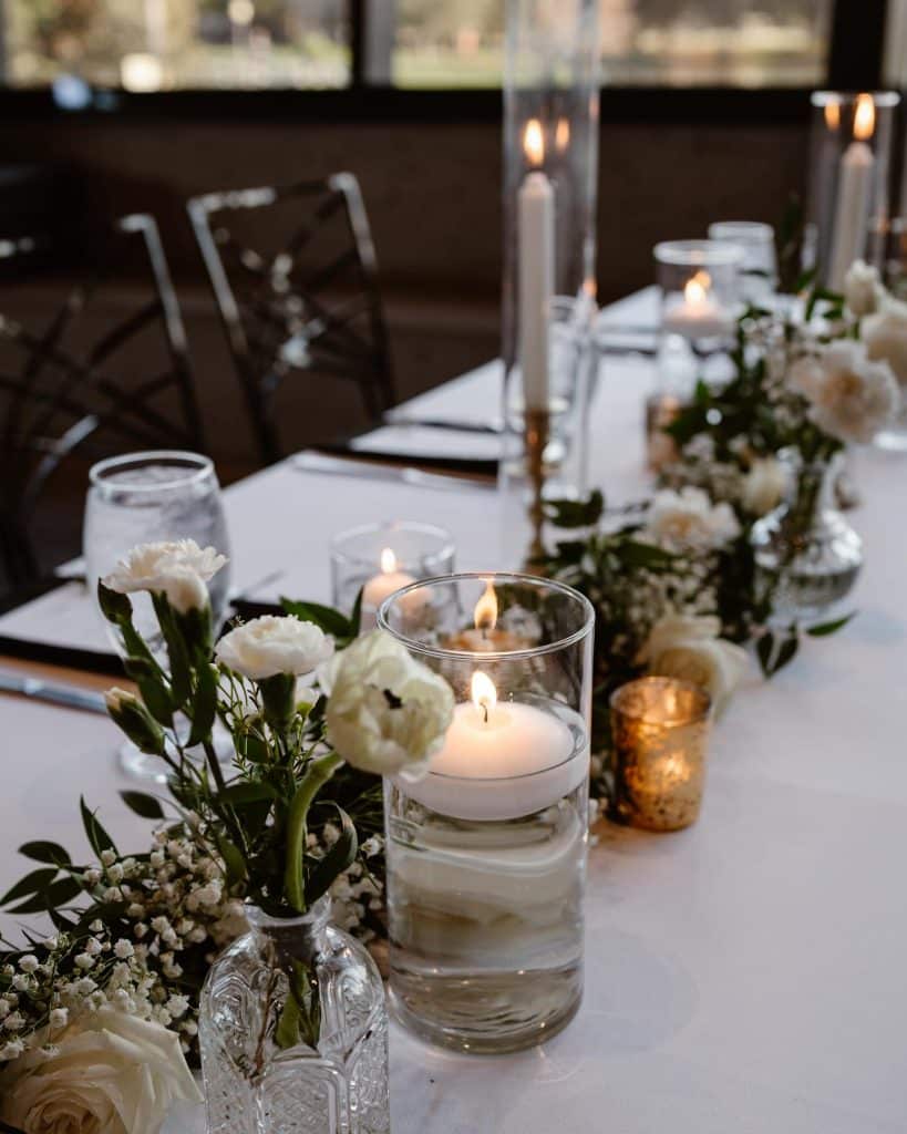 table set for a reception, centerpieces down the middle, candles lit, Orlando, FL