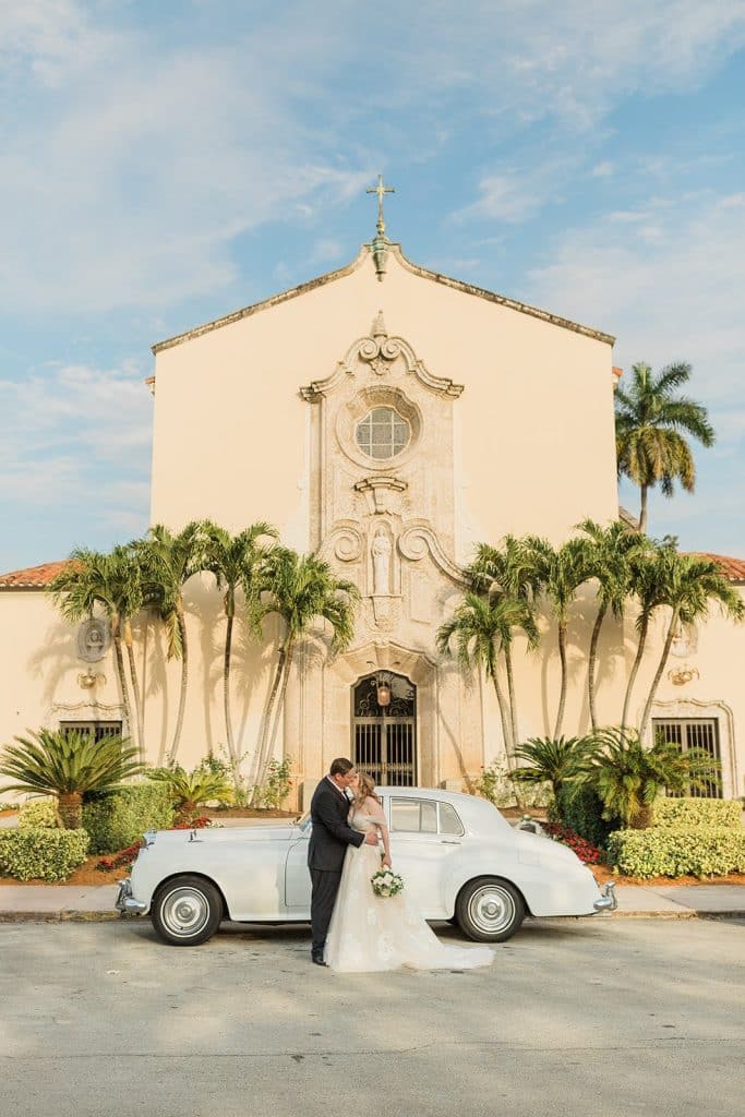 bride and groom standing in front of a classic car, outside their wedding ceremony location, church, palm trees, Naomi Zora Events, Orlando, FL