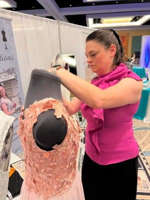 woman making alterations to a pink dress, on a mannequin, Orlando, FL