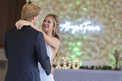 bride and groom dancing at their reception, I DO Sign lit up, neon sign stating Always & Forever on the wall, Orlando, FL