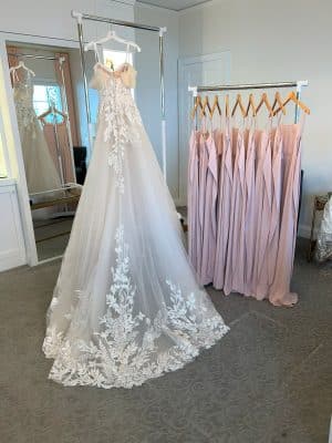 beautiful wedding dress hanging from a rack, train is spread out for display, Sewing by Marilyn, Orlando, FL
