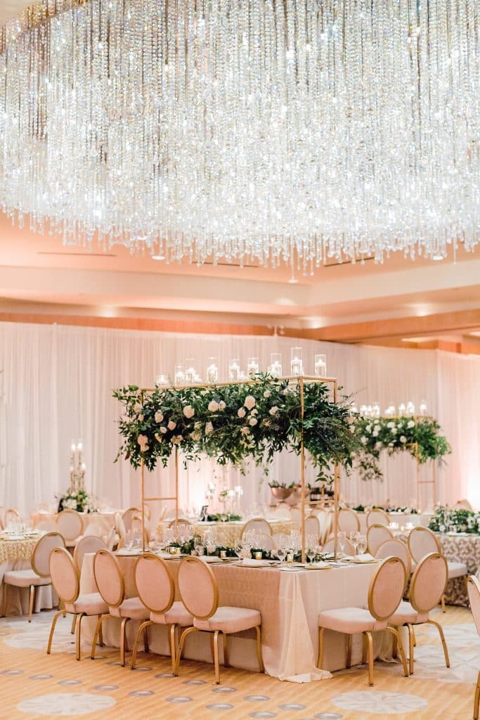 event set up, large floral display hanging above the main table, light pink tablecloth, pink chairs, set for 12, Orlando, FL