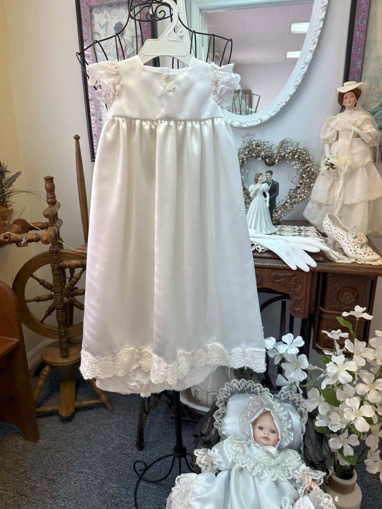 white doll dress, hanging on display, dolls on the table and floor, Orlando, FL